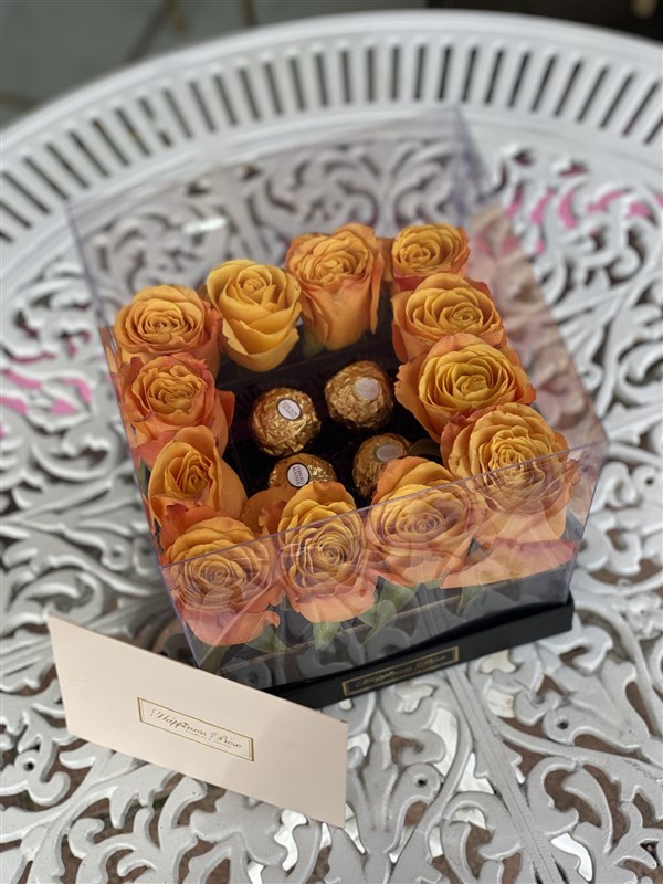 Kare Şeffaf Kutuda Turuncu Güller ve Çikolatalar