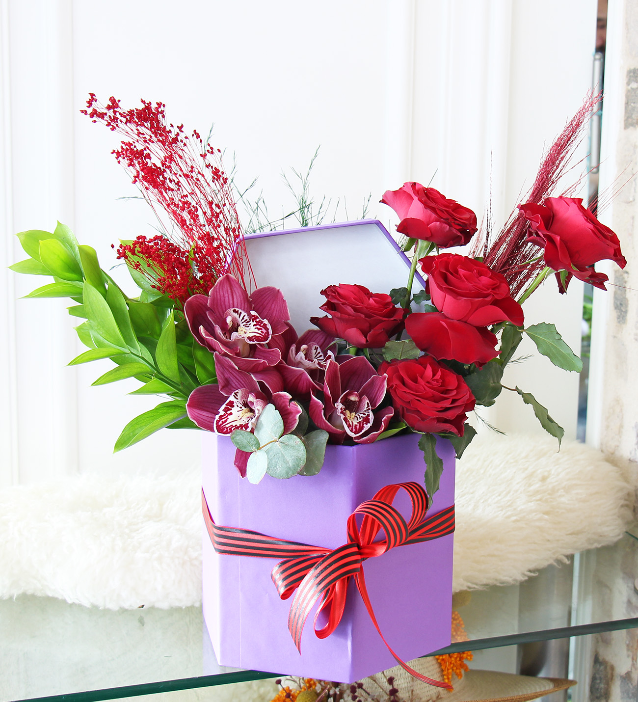 Lila seri kutu kırmızı güller ve bordo simbidyum orkide aranjmanı