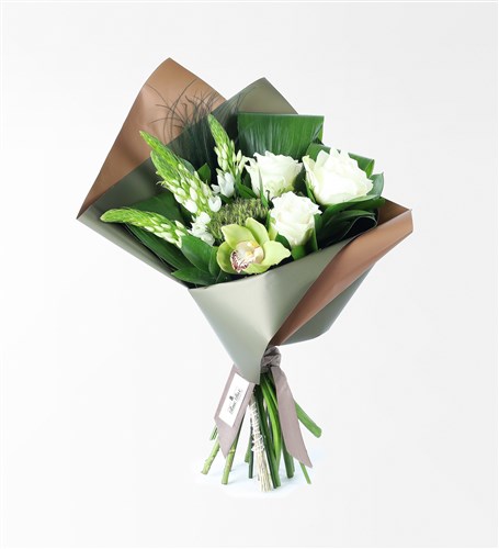 A bouquet of white flowers in a green coffee package.