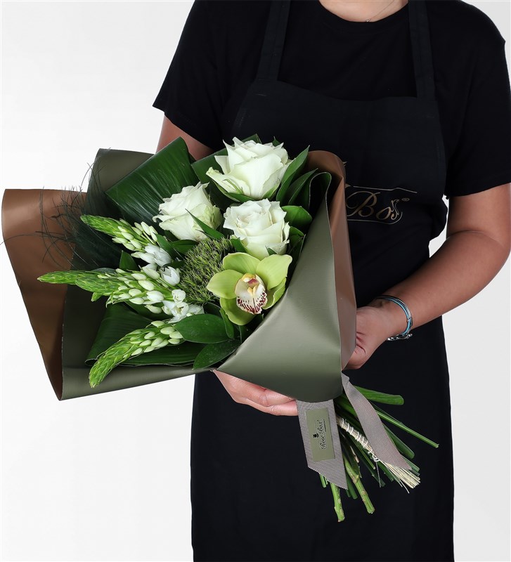A bouquet of white flowers in a green coffee package.